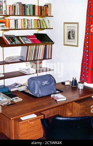 Interno di uno studio in una casa moderna interni a Hampstead, Londra, Inghilterra, Regno Unito negli anni '60 con una macchina da scrivere coperta su una scrivania e librerie Foto Stock