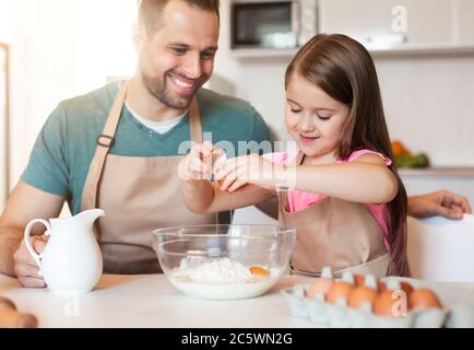 Papà e figlia che fanno i biscotti di cottura dell'impasto insieme a casa Foto Stock