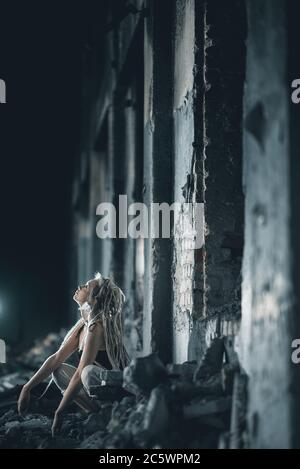 Giovane donna bionda con dreadlock in rovinata fabbrica Foto Stock