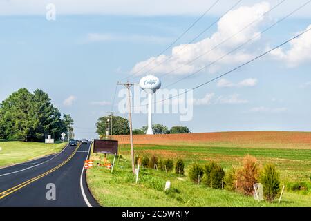 Culpeper, USA - 9 giugno 2020: Vista del segno della torre dell'acqua per la città in Virginia campagna città rurale contro cielo e strada lastricata da campi agricoli Foto Stock