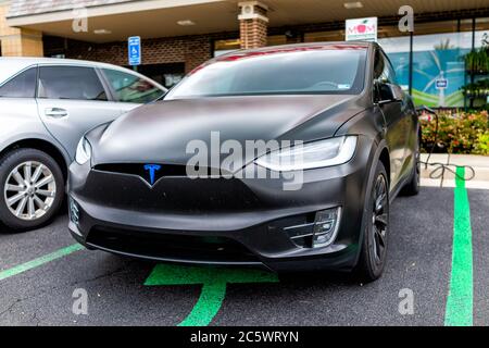 Herndon, USA - 11 giugno 2020: L'esterno del negozio di Mum's Organic Market sulla strada nella Virginia Fairfax County e la closeup Tesla modello X carica auto presso pa Foto Stock