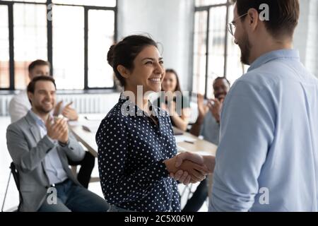 Happy indiano dipendente ottenere promozione ricevere lodi handshake con boss Foto Stock