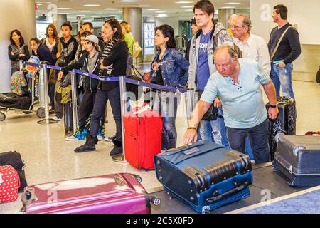 Miami Florida International Airport mia, volo in arrivo, ritiro bagagli, bagaglio, carosello valigia, nastro trasportatore, uomo uomini maschio adulti, donna donne fe Foto Stock