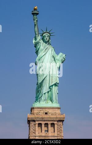 Una vista della Statua della libertà a New York, con un cielo blu chiaro dietro Foto Stock