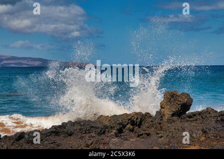 Onde che si schiantano contro la roccia vulcanica su Maui. Foto Stock