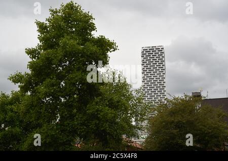 Il nuovo condominio residenziale torre Vancouver House si distingue contro il cielo sopra gli alberi a Vancouver, British Columbia, Canada. Foto Stock