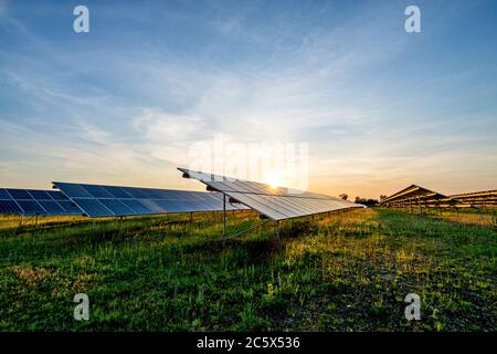 centrale fotovoltaica montata a terra al tramonto Foto Stock