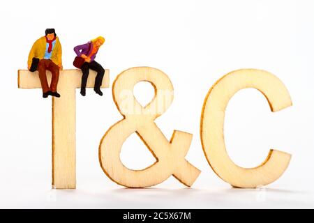 Termini e condizioni abbreviati con t&c con una coppia di figure in miniatura sulla lettera T Foto Stock