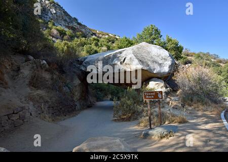 Tunnel Rock, un'ex strada che attraversa un tunnel fatto di granito. Un segno che descrive è davanti alla roccia. Sequoia National Park, California. Foto Stock