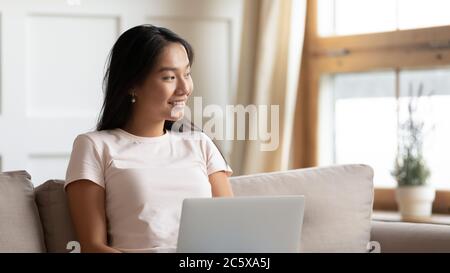 Sorridente bella giovane donna asiatica che visualizza il futuro. Foto Stock