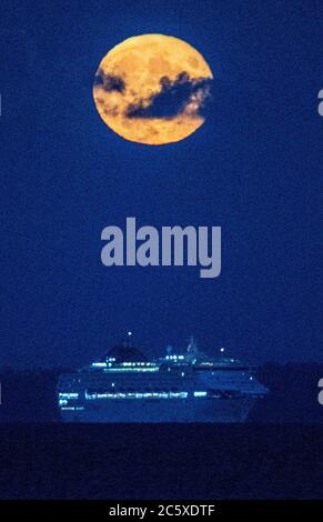 Isola di Wight. 5 luglio 2020. Regno Unito Meteo. La luna piena, conosciuta come la Luna del Buck o la Luna del Tuono sorge dietro la nave da crociera Oceana sul Solent con l'Isola di Wight sullo sfondo. Credit Stuart Martin/Alamy Live News Foto Stock