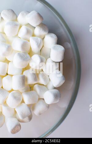 Una ciotola di vetro riempita con mini marshmallows Foto Stock