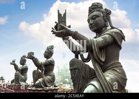 Statue buddiste che lodano vicino al Buddha gigante a Hong Kong durante il giorno d'estate Foto Stock