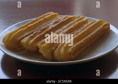 Churros spagnoli tradizionali su un piatto. Un impasto fritto Foto Stock