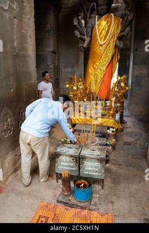 Statua di Buddha e adoratori in Angkor Wat. Siem Reap, Cambogia Foto Stock