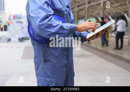 Il meccanico sta utilizzando un tablet. Foto Stock