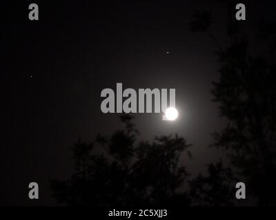 Sheerness, Kent, Regno Unito. 5 luglio 2020. Regno Unito Meteo: La luna piena buck visto con i pianeti Saturno (sinistra) e Giove (destra) nel cielo notturno sopra Sheerness, Kent. Credit: James Bell/Alamy Live News Foto Stock