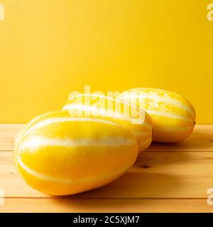 Melone orientale coreano su tavolo di legno, con fondo giallo Foto Stock