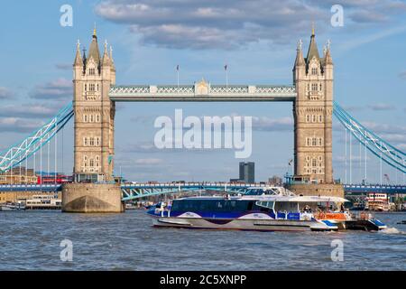 Catamarano Thames Clipper accanto al Tower Bridge sul fiume Tamigi Foto Stock