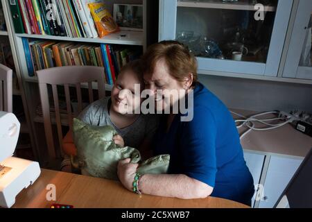 Nonna e nipote abbracciano e sorridono dopo aver cucito un cuscino insieme. Zawady Gmina Rzeczyca Polonia Foto Stock