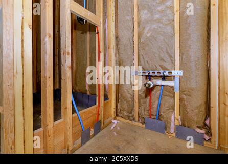 Costruzione domestica con disposizione del tubo di pex rosso caldo e blu freddo in nuova casa della vasca sistema di acqua di spreco di PVC Foto Stock