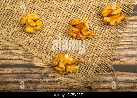 Noci pelate sfuse su un tavolo di legno coperto di tela ruvida. Dieta sana. Dieta di idoneità. Primo piano Foto Stock