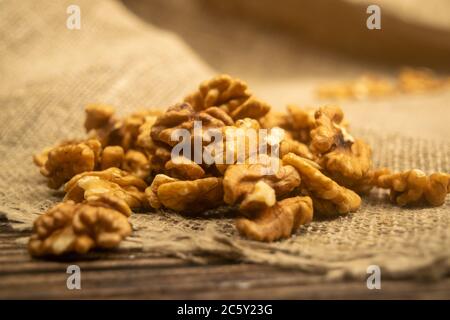 Noci pelate sfuse su un tavolo di legno coperto di tela ruvida. Dieta sana. Dieta di idoneità. Primo piano Foto Stock