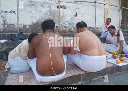 Sacerdoti indù e uomini con archi Brahmin (yagnopavit, janei, janeu) in un rito commemorativo (sharaddh) per un parente defunto; carro armato di Banganga, Mumbai, India Foto Stock