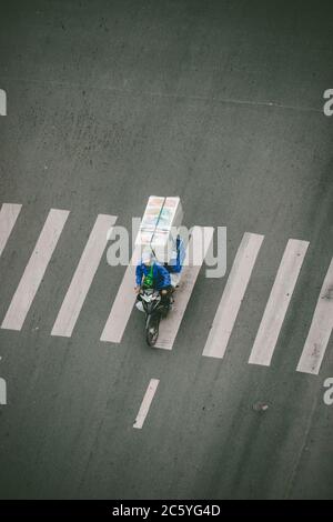 Saigon, Vietnam - 4 luglio 2020: Le strade di Saigon (ho Chi min City), un uomo ingombrante stava passando una luce rossa. Foto Stock