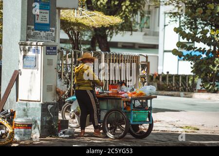 Saigon, Vietnam - 4 luglio 2020: Le strade di Saigon (ho Chi min City), donna che spinge i carrelli per la colazione sul marciapiede Foto Stock