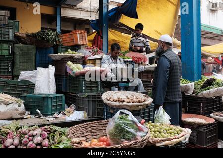 Un uomo che acquista verdure da un mercato in Old Delhi, India Foto Stock