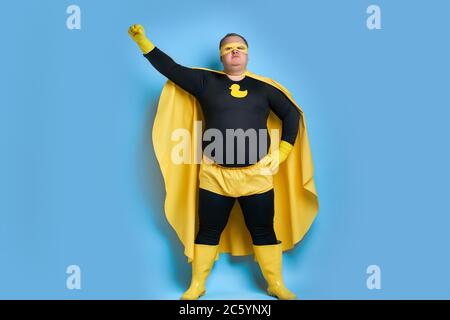 Supereroe grasso caucasico maschio in maschera e guanti protettivi in posa. L'uomo sembra MR.proper, andando a pulire tutto sulla sua strada Foto Stock