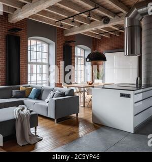 Interno soppalco con soffitto in legno, divano ad angolo e cucina isola Foto Stock