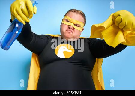 ritratto di supereroe pulizia entusiasta isolato su sfondo blu. anatra gialla è un simbolo di bagno e pulizia. l'uomo è pronto per pulire Foto Stock