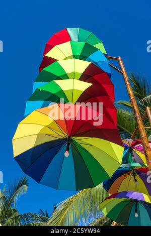 Luci di strada decorate con ombrelli colorati appendono su una colonna in strada contro il cielo blu in una giornata di sole, Vietnam Foto Stock