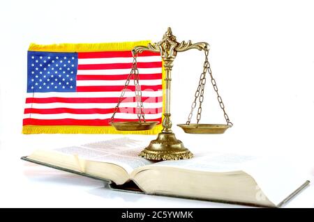 Scale di giustizia sul libro e bandiera degli Stati Uniti su bianco Foto Stock