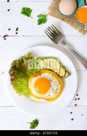 Uova fritte in un anello di peperone giallo. Cibo sano per la colazione. Nutrizione adeguata. La vista dall'alto Foto Stock