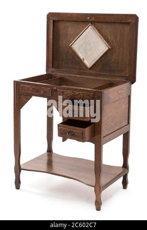 Antica scrivania in legno con cassetti e sculture in legno su sfondo bianco. Foto Stock