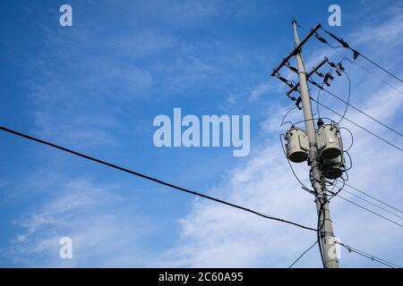 trasformatori e fili collegati a un palo telefonico. Foto Stock