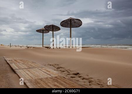 I tavoli coperti di sabbia sulla spiaggia di Egmont aan Zee, Paesi Bassi. La spiaggia senza turisti stranieri dopo la pandemia coronavirus. Foto Stock