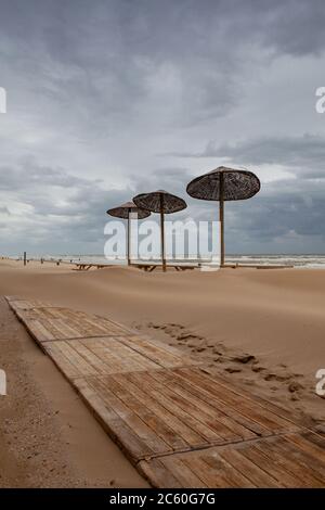 I tavoli coperti di sabbia sulla spiaggia di Egmont aan Zee, Paesi Bassi. La spiaggia senza turisti stranieri dopo la pandemia coronavirus. Foto Stock