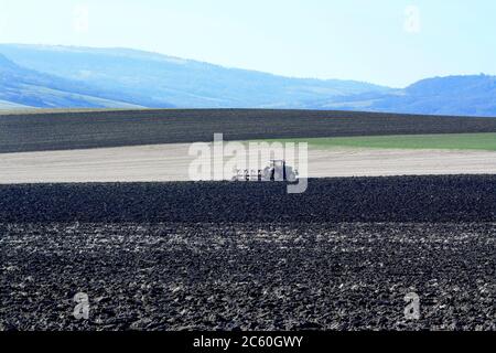 Campo di aratura trattore , Puy de Dome, Auvergne-Rhone-Alpes, Francia Foto Stock