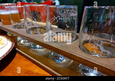 Set di bicchieri per la degustazione di birra su stand in legno. Diversi tipi di birra Foto Stock