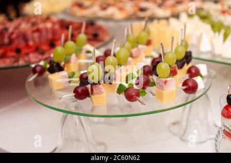 canapes con formaggio, prosciutto e uva su bastoncini Foto Stock