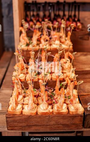 Buffet di nozze. Gamberi con crostini su un supporto in legno Foto Stock