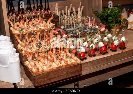 Buffet di nozze. Gamberi con crostini su un supporto in legno Foto Stock