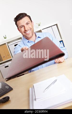 I candidati consegnano i loro documenti al personale delle risorse umane durante il colloquio di lavoro Foto Stock