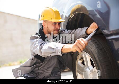 Ritratto di giovane meccanico in abiti da lavoro e cambio di hardhat Foto Stock