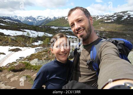 Selfie di coppia del viaggiatore nella zona escursionistica della Norvegia - catena montuosa nella contea di Hordaland. Sentiero della lingua di Troll. Attività all'aperto. Foto Stock