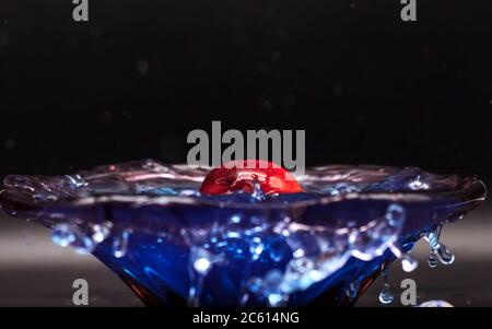 Una mela si tuffa nell'acqua su sfondo nero Foto stock - Alamy